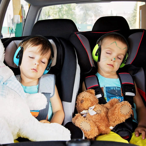 Two toddlers wearing blue and green Four Pack Kids Ear Protection Earmuffs Adjustable Noise Reduction 27NRR sleeping in car seats