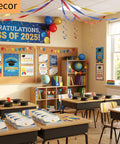 Classroom decorated for graduation with colorful balloons, banners, and books on desks for Class of 2025 celebration.