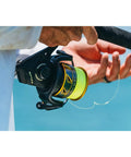Angler holding Battle III Inshore Spinning Reel with HT-100 Front Drag, 12 lb max drag, all aluminum construction, black gold finish.