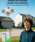 Child watching Mini Drone For Kids With 360 Degree Flips, LED Lights, And Easy Flight Features hovering near houses on a sunny day.