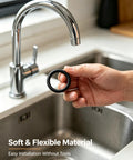 Hand holding black O ring from Premium 250 Piece O Ring Assortment Kit With 15 Sizes Nitrile Rubber Seals Set near kitchen faucet