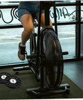 Person using exercise bike with visible belt discs; Exercise Bike Belt Discs For Workouts And Pulley System Dynamic Cycling Belt Wheel Home Gym Accessory Durable ABS Construction With Wide Bike Compatibility.