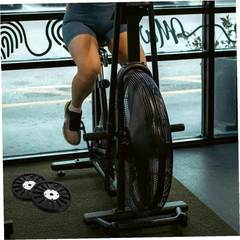 Person using exercise bike with visible belt discs; Exercise Bike Belt Discs For Workouts And Pulley System Dynamic Cycling Belt Wheel Home Gym Accessory Durable ABS Construction With Wide Bike Compatibility.