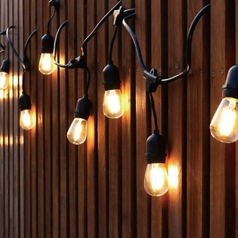24 Pack LED S14 Replacement Bulbs For Outdoor String Lights, 1 Watt 2200K Warm White, E26 Medium Base, glowing on a wooden wall