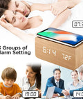 Dope Wooden Digital Alarm Clock With Qi Wireless Charging Pad For iPhone Samsung Featuring Smart Clap Activated Wake Light Plus Room Temperature Tracker next to sleeping couple.