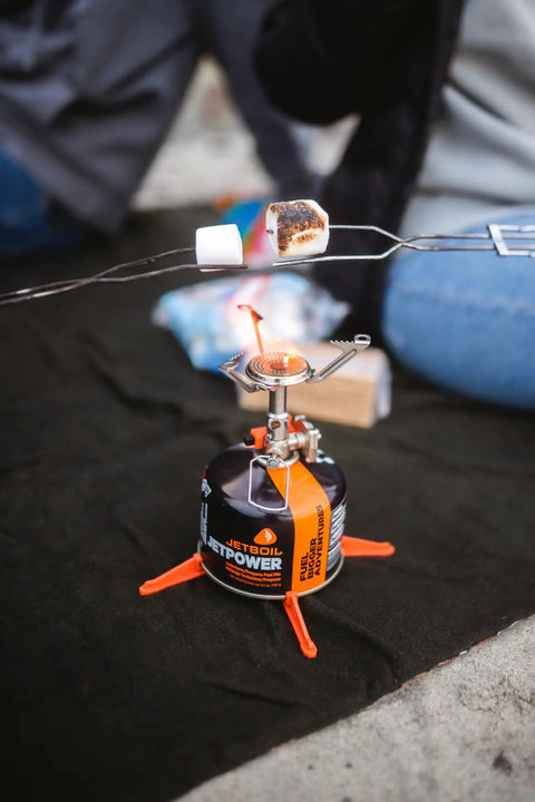 Ultralight Camping Stove That Boils Water In About 3 Minutes in use with marshmallows on sticks over the flame