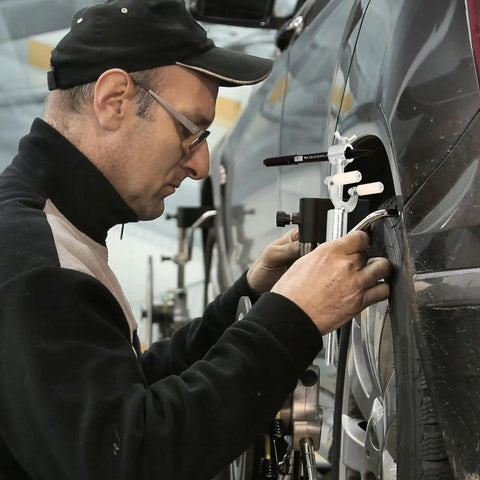 Person using DIY Auto Body Dent Repair Kit With Wheel Arch Marker And Iron Tool For Sheet Metal Restoration on car