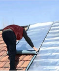 Person applying Self Adhesive Roof Repair Tape With Waterproof Polymer Asphalt And Reinforced Aluminum Foil Backing on roof shingles.
