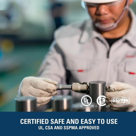 Technician inspecting a part in a factory with safety certifications displayed, emphasizing quality assurance.