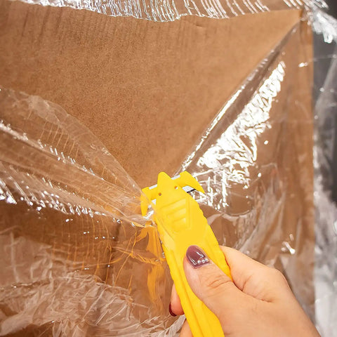 Person using 50 Pack Safety Box Cutter With Double Sided Concealed Blade Stainless Steel Package Opener For Shipping And Mail on plastic wrap