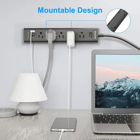 8 In 1 Surge Protector Power Strip With 5 Widely Spaced Outlets 3 USB Ports Including USB C Port 1250 Watt 10 Amp 5 Ft Extension Cord Wall Mountable For Home Office Black mounted on wall with laptop and lamp