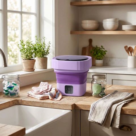 Top Slick 6 Liter Portable Mini Washer Folds Flat For Cramped Dorm Spaces on kitchen counter beside laundry items.