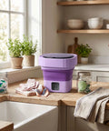 Slick Mini Folding Washing Machine 6 Liter Portable Unit with collapsible body on kitchen counter, surrounded by laundry essentials.