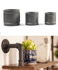 Heavy Duty One Half Inch Cast Iron Floor Flange Fittings For DIY Furniture And Shelving Projects Black DN15 Pipe Connections 4 Pack Pre Drilled Holes For Quick Install displayed with other pipe fittings and a shelf setup.