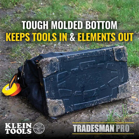 Tradesman Pro Wide Open Tool Bag With 1680 Ballistic Weave Molded Bottom on muddy ground, showcasing durability.