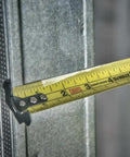 Close-up of NGT 25 Foot Tape Measure with One and a Quarter Inch Tape and high visibility blade measuring metal surface