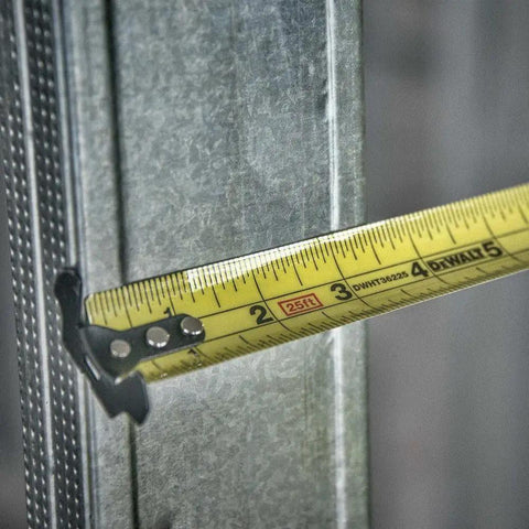 Close-up of NGT 25 Foot Tape Measure with One and a Quarter Inch Tape and high visibility blade measuring metal surface