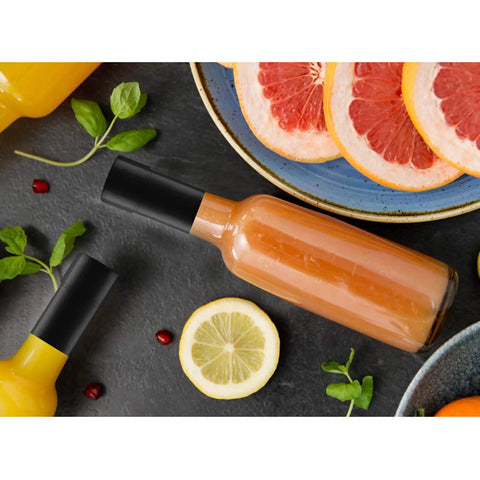 Bottle on table with Shrink Bands 50x60mm Black Pack Of 200 Tamper Evident Seal For Hot Sauce And Other Liquids, colorful fruits around.