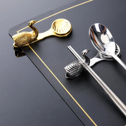 Stainless Steel Cutlery Holder Rack with gold and silver swan design on restaurant table; Durable Utensil Stand.