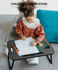 Child using foldable laptop bed desk with cup holder, tablet slot, lifting handle for drawing on the floor.