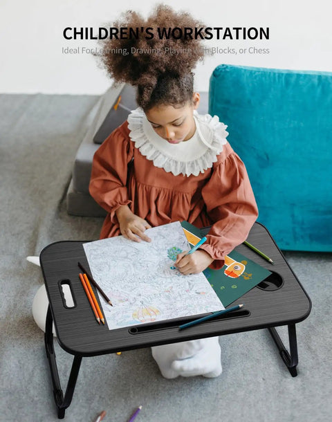 Child using foldable laptop bed desk with cup holder, tablet slot, lifting handle for drawing on the floor.