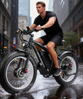 Person riding Beast Dual Motor Electric Bike for Adults with 52V 34Ah Battery, 24x4 fat tires, in urban setting with water splash.