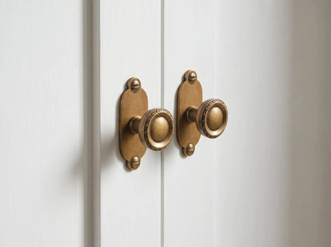 Top Notch Heavy Duty Solid Zinc Cabinet Knobs With Vintage Oval Beaded Back Plates Antique Brass Finish Six Pack installed on cabinets.