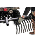 Heavy Duty ATV UTV Landscape Rake For Rock Debris Removal, man attaching rake with removable tines to an ATV.
