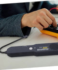 Must Have Multi Functional Car Short Circuit Tester And Wire Breaker Tracker Kit placed on a table next to technician's hand
