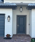 Modern Outdoor Wall Sconces 2 Pack With Dusk To Dawn Sensor, black glass sconces flanking a gray front door.