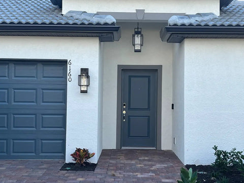 Modern Outdoor Wall Sconces 2 Pack With Dusk To Dawn Sensor, black glass sconces flanking a gray front door.