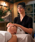 Therapist wearing Disposable No Fuss Hair Nets For Food Service Black Nylon 28 Inch Pack Of 100 during facial massage.