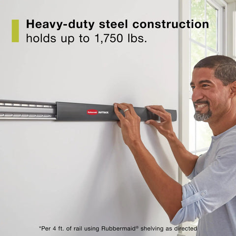 Man installing FastTrack Garage Wall Mounted Storage Kit with four rails and eleven hooks on a wall, heavy-duty steel, supports up to 1,750 lb