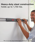 Man assembling FastTrack 24 Piece Garage Wall Mounted Storage Kit With 6 Rails And 18 Hooks In Black Heavy Duty Steel