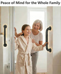 Rock Solid 16 Inch Wall Mount Handrail Matte Black Steel Pipe Grab Bar used by a woman and girl in a bathroom for safety.