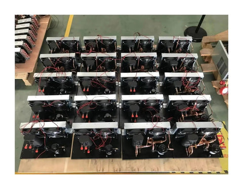 Multiple portable micro air conditioners with plates and compressors in a factory setup for 200W performance and 24V DC support.