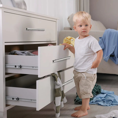 Child standing by dresser with 100 Pieces Brushed Stainless Steel Cabinet Pulls 3 Inch Hole Center Handles, open drawers with clothes.