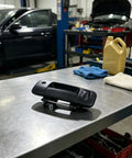 RDHFTNIHU Access Latch Component on a workbench, showcasing durable black plastic design for truck tailgate use.