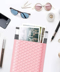 Light Pink 4x8 Inch Bubble Mailers 50 Pack Self Seal Padded Poly Mailers For Small Biz Shipments, Opaque Matte Bubble Bags, Chic Packaging Bags For Safe And Stylish Shipping on a desk with stationery