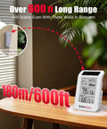 Wireless Weather Station With Dual Zone Indoor Outdoor Monitor For Home And Kids Room 100m Range Temp Humidity Barometric Trend Visualization Auto Backlight Easy Setup White And Orange displayed on table next to plant with 600 ft range text