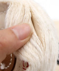 Hand holding the edge of an Ultimate Cotton Polishing Wheel For Fast Buffing And Mirror Shining On Metal Wood And Plastic.