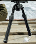 Quick Release Rifle Bipod With 360 Degree Swivel And Tilt Head on wooden surface, adjustable legs for stable shooting.
