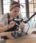 Person using Soldering Desk Magnifier With Heavy Duty Base Adjustable Swivel Arm 5 Diopter Real Glass Lens Three Color LED Modes PCB Circuit Board Holder