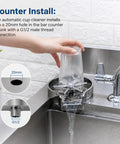 Slick Automatic Glass Rinser Head Powered By Standard Faucet Pressure For Quick Hands Free Cup Cleaning Heavy Duty Sink Attachment installed with a glass under rinsing water.