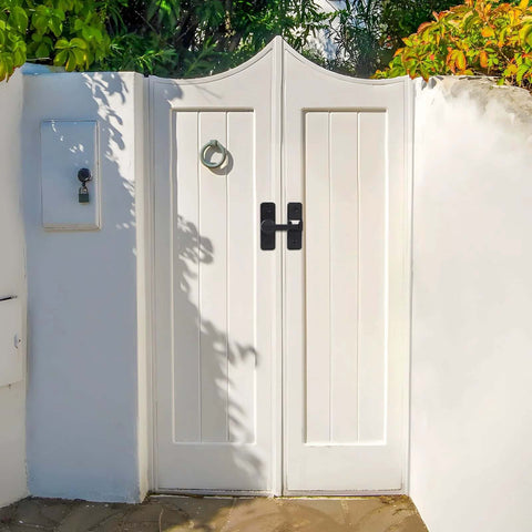 White double gate with 2 Pack Heavy Duty 180 Degree Barn Door Lock Hardware With Thickened Flip Latches, matte black finish, installed outdoors.
