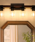 4 Light Farmhouse Vanity Light Fixture With Antique Wood Style Pole And Clear Glass Shades Over Mirror in Bathroom