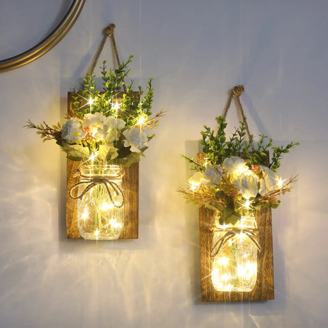 Remote Control Mason Jar Sconces Set Of Two With LED Fairy Lights And White Rose Accents on rustic boards for cozy wall decor.