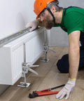 Worker using Two Pack Labor Saving Arm Jacks For Lifting Furniture With 330 Lbs Capacity to install a radiator