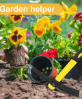 Three Pack 15 Inch Garden Pick Axes With Fiberglass Handles, Double Head Cast Steel Heads For Gardening, Camping, Prospecting, And Outdoor Activities next to plants being planted in garden soil