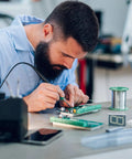Person soldering on a 12 Pack 2 By 2.8 Inch Single Sided PCB Prototyping Boards For DIY Electronics Projects Yellow Copper Plated FR4 Breadboard